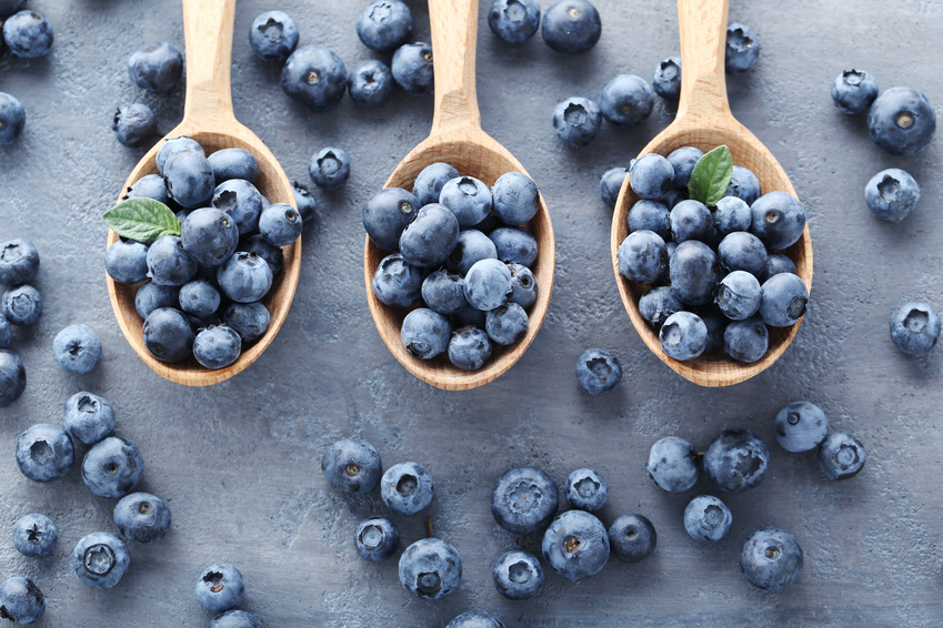 Ripe and tasty blueberries on grey wooden table