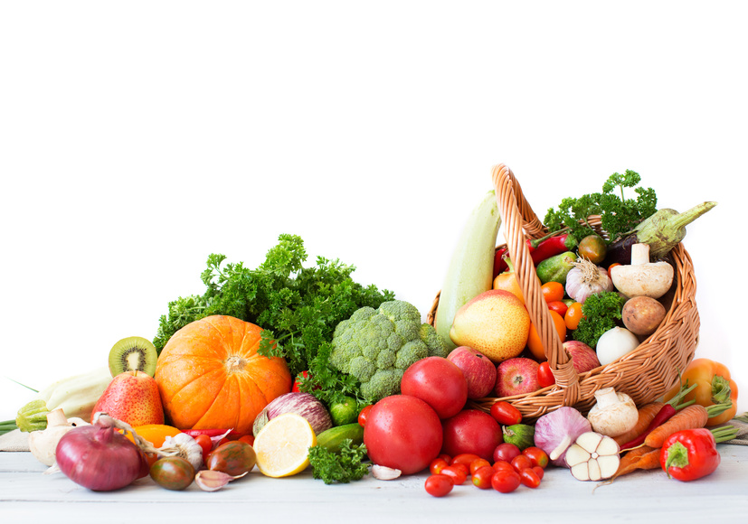 Composition with vegetables and fruits in wicker basket isolated on white.